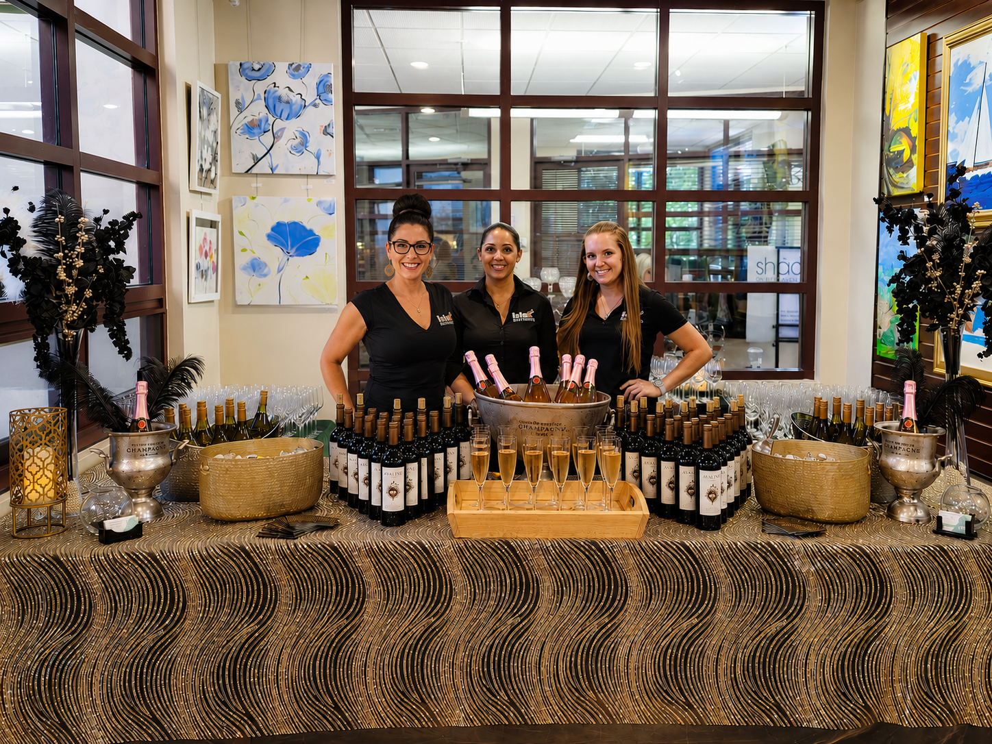 Three ISLE Bartend hospitality professionals in black behind a champagne and wine bar