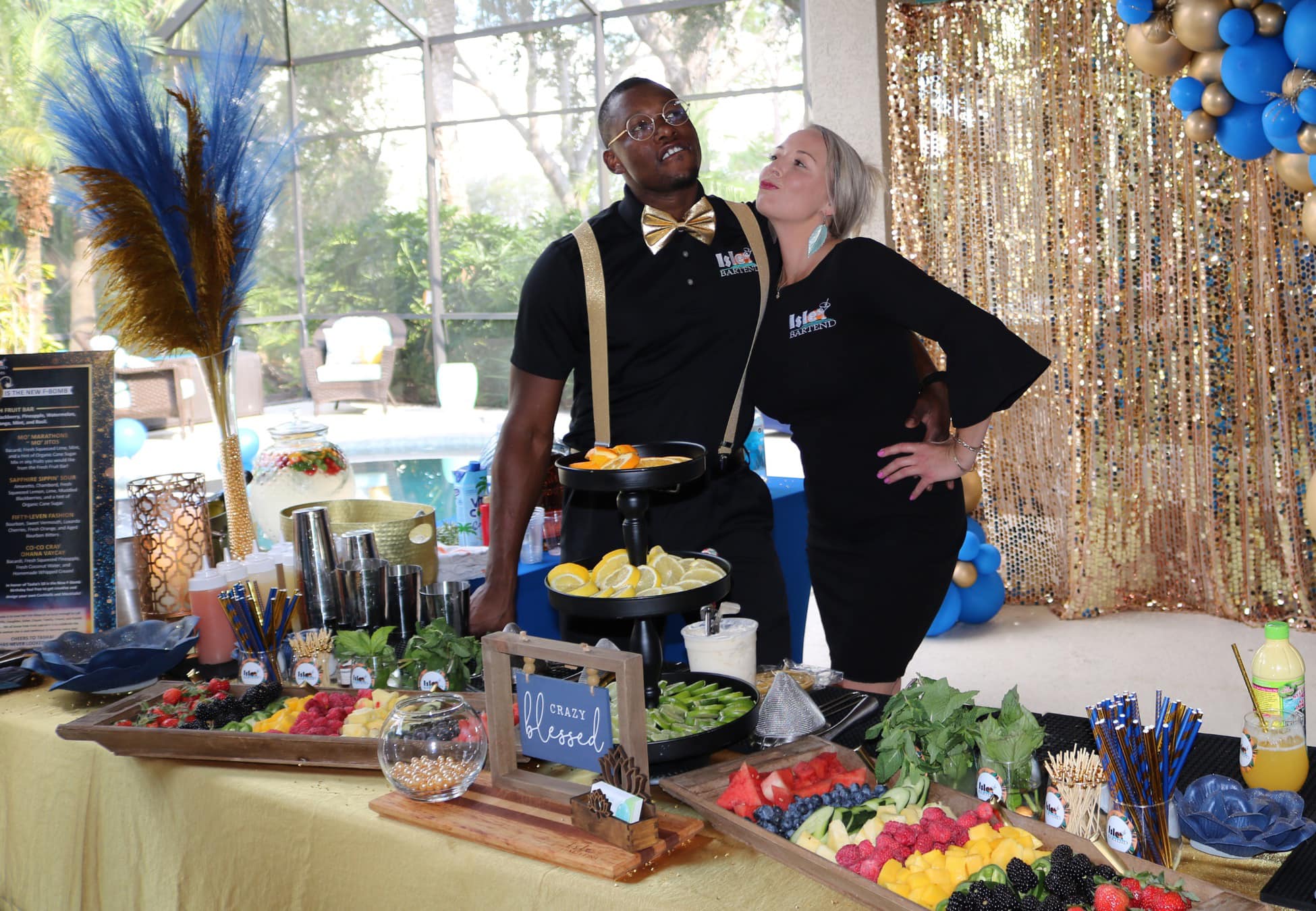 ISLE Bartend team beside a fresh fruit bar with cut citrus and berries at a private event